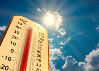 climate change, low angle view Thermometer on blue sky with sun shining in summer show increase temperature, concept global warming