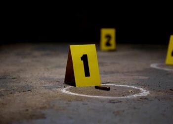 Wide pan of crime scene markers of bullet casings on a concrete floor