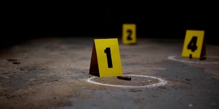 Wide pan of crime scene markers of bullet casings on a concrete floor